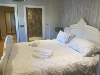 a white bed with towels on top of it at The Oaks Stable cottage in Haughley
