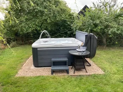 a bath tub sitting in the grass with a table at The Suites at Pannells Ash in Castle Hedingham