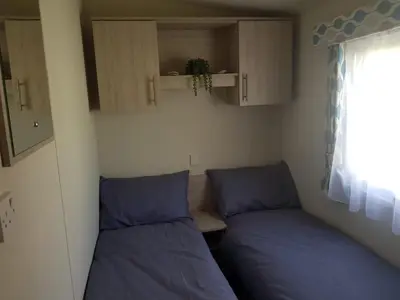 a small room with two beds and a window at Lodge Sleeps 8- Parking Wifi Campsite Amenities in Jaywick Sands