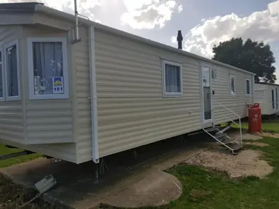 a mobile home is parked in a yard at Lodge Sleeps 8- Parking Wifi Campsite Amenities in Jaywick Sands