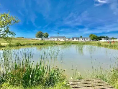a body of water with houses in the background at Lodge Sleeps 8- Parking Wifi Campsite Amenities in Jaywick Sands