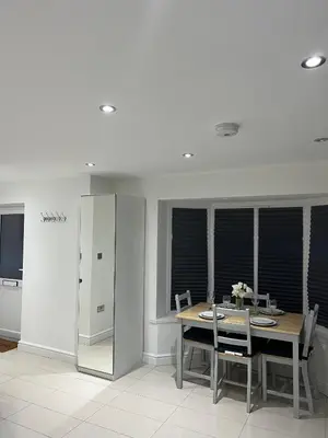 a dining room with a table and chairs and windows at Lovely holiday home in Southminster in Southminster