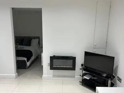 a living room with a television and a bed at Lovely holiday home in Southminster in Southminster