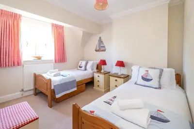 a twin bedroom with two beds and a window at 12 Prevetts Way - Aldeburgh Coastal Cottages in Aldeburgh