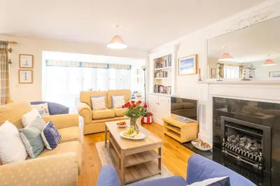 a living room with a fireplace and blue furniture at 12 Prevetts Way - Aldeburgh Coastal Cottages in Aldeburgh