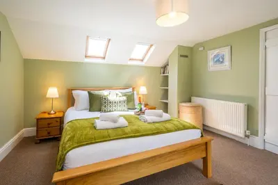 a bedroom with a large bed with two towels on it at Laurel Cottage - Aldeburgh Coastal Cottages in Blyford