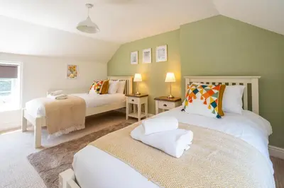 a bedroom with two beds and a window at Laurel Cottage - Aldeburgh Coastal Cottages in Blyford