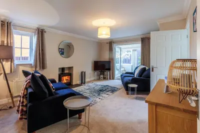 a living room with two blue couches and a fireplace at Potters Brook in Framlingham
