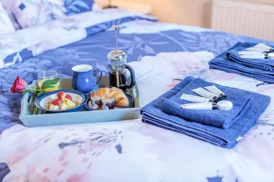 a tray of food and a breakfast on a bed at Potters Brook in Framlingham