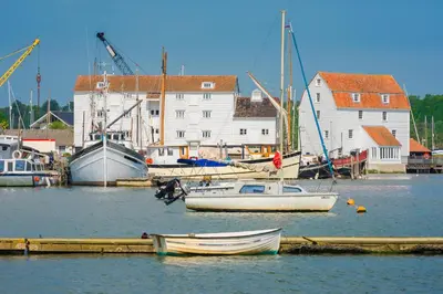 a group of boats are docked in a harbor at Potters Brook in Framlingham