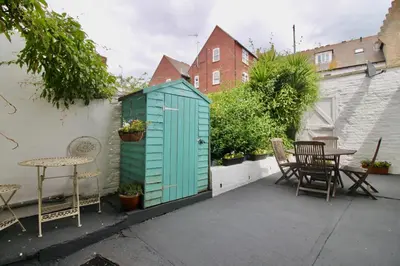 a smallshed with chairs and a table on a patio at West Street Retreat Grade II listed townhouse in Harwich