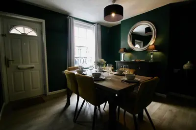 a dining room with a table with chairs and a mirror at West Street Retreat Grade II listed townhouse in Harwich