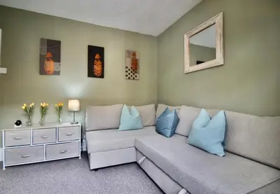 a living room with a couch and a mirror at West Street Retreat Grade II listed townhouse in Harwich