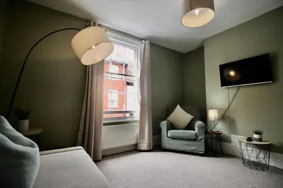 a living room with a chair and a window at West Street Retreat Grade II listed townhouse in Harwich