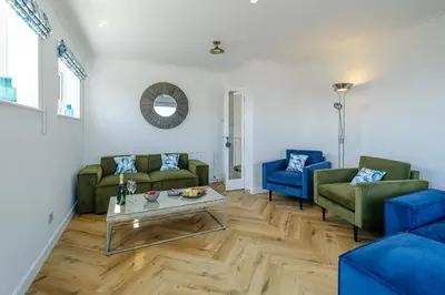 a living room with two couches and a table at Skippers Cottage - Aldeburgh Coastal Cottages in Aldeburgh