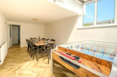 a dining room with a table and a large window at Skippers Cottage - Aldeburgh Coastal Cottages in Aldeburgh