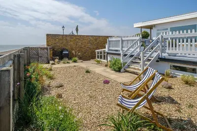 a pair of chairs sitting in a yard next to a house at Skippers Cottage - Aldeburgh Coastal Cottages in Aldeburgh