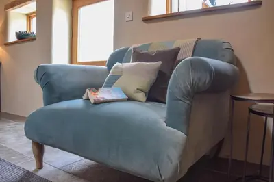 a blue chair with a book on top of it at Halcyon Barn, Wissett in Wissett