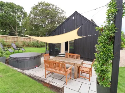 a patio with a table and chairs and a fire pit at Halcyon Barn, Wissett in Wissett