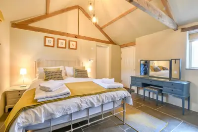 a bedroom with a bed and a blue desk at Halcyon Barn, Wissett in Wissett