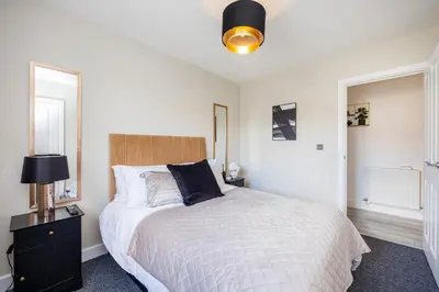 a bedroom with a bed and a lamp on a table at Modern 1BR By Luxiety Stays Short Lets & Serviced Accommodation Southend on sea - City Centre, Nr the beach, High St & Adventure Island in Southend-on-Sea