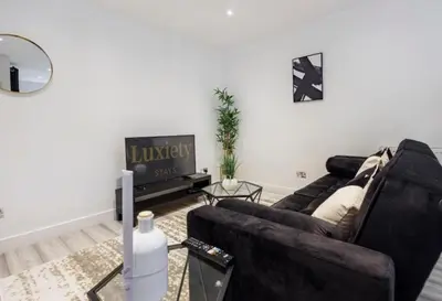a living room with a couch and a tv at Modern 1BR By Luxiety Stays Short Lets & Serviced Accommodation Southend on sea - City Centre, Nr the beach, High St & Adventure Island in Southend-on-Sea