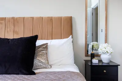 a bed with black and white pillows and a mirror at Modern 1BR By Luxiety Stays Short Lets & Serviced Accommodation Southend on sea - City Centre, Nr the beach, High St & Adventure Island in Southend-on-Sea