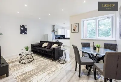 a living room with a black couch and a table at Modern 1BR By Luxiety Stays Short Lets & Serviced Accommodation Southend on sea - City Centre, Nr the beach, High St & Adventure Island in Southend-on-Sea