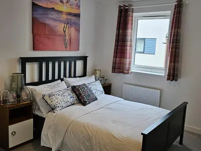 a bedroom with a bed with pillows and a window at Modern 3 Bedroom Town House in Ipswich