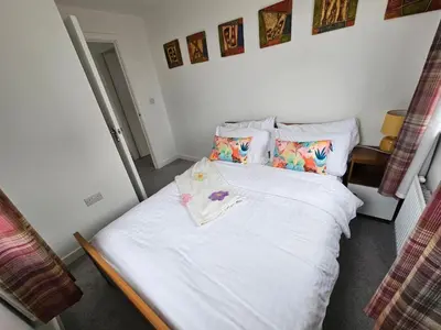 a bedroom with a bed with white sheets and pillows at Modern 3 Bedroom Town House in Ipswich