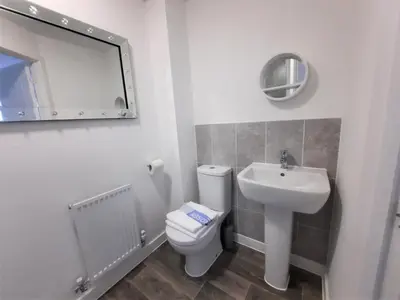 a bathroom with a toilet and a sink and a mirror at Modern 3 Bedroom Town House in Ipswich