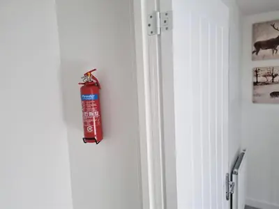 a fire extinguisher hanging on the side of a door at Modern 3 Bedroom Town House in Ipswich