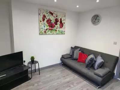 a living room with a couch and a television at Vetrelax Colchester Three bedroom house- Sleeps up to 7 - Free Wi-Fi - Contractors - Families - Long Term Stays in Colchester