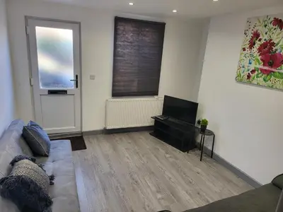 a living room with a couch and a flat screen tv at Vetrelax Colchester Three bedroom house- Sleeps up to 7 - Free Wi-Fi - Contractors - Families - Long Term Stays in Colchester