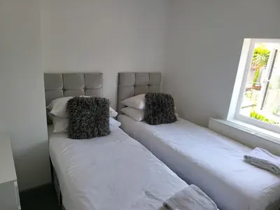 two beds sitting next to each other in a room at Vetrelax Colchester Three bedroom house- Sleeps up to 7 - Free Wi-Fi - Contractors - Families - Long Term Stays in Colchester