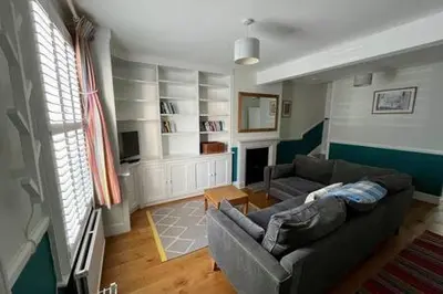 a living room with a couch and a fireplace at Charming 1 bed super central Terraced House in Cambridge