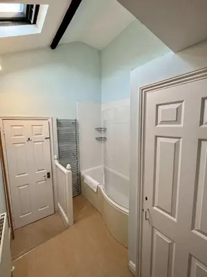 a bathroom with a tub and a white door at Charming 1 bed super central Terraced House in Cambridge