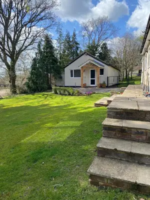 a house with a grass yard with a house at Chase Bungalow in Billericay