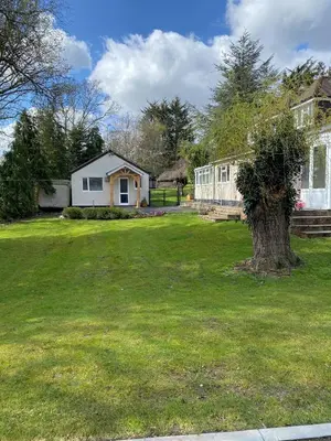a yard with a house and a tree at Chase Bungalow in Billericay