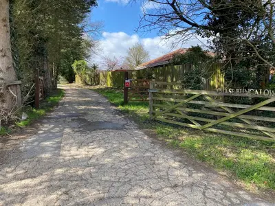 a wooden fence next to a dirt road at Chase Bungalow in Billericay