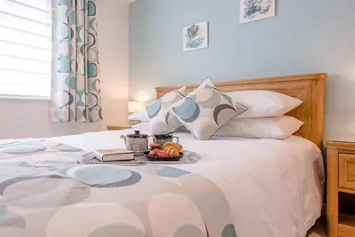 a white bed with a tray of fruit on it at Hattie's, Great Glemham in Saxmundham