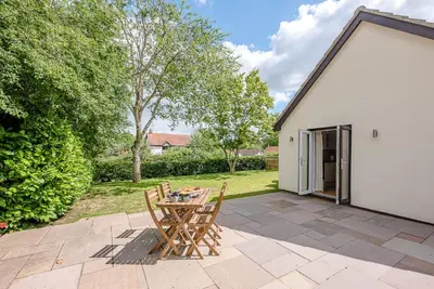 a patio with a table and chairs in a yard at Hattie's, Great Glemham in Saxmundham