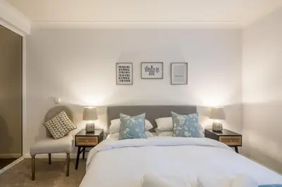 a bedroom with a large bed and two chairs at Lovely 1 Bed Apartment With FREE PARKING & Garden in Cherry Hinton