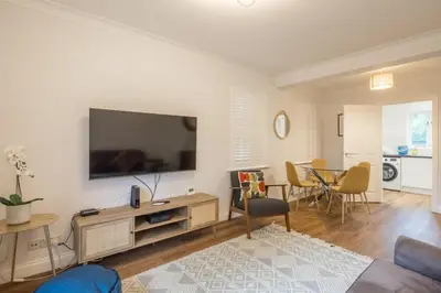 a living room with a flat screen tv on a wall at Lovely 1 Bed Apartment With FREE PARKING & Garden in Cherry Hinton
