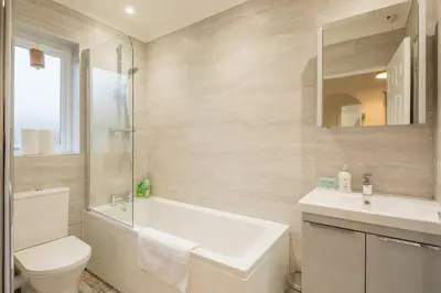 a bathroom with a sink and a tub and a toilet at Lovely 1 Bed Apartment With FREE PARKING & Garden in Cherry Hinton