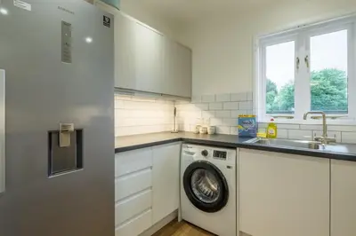 a kitchen with a washing machine and a sink at Lovely 1 Bed Apartment With FREE PARKING & Garden in Cherry Hinton