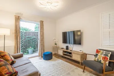 a living room with a couch and a flat screen tv at Lovely 1 Bed Apartment With FREE PARKING & Garden in Cherry Hinton