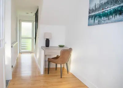 a chair sits next to a desk in a hallway at Parkside House Stevenage in Stevenage
