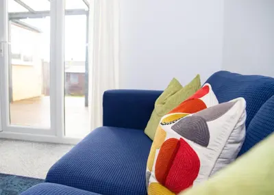 a blue couch with pillows on it in a living room at Parkside House Stevenage in Stevenage