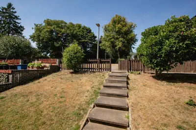 a pathway in a yard with a wooden fence at Parkside House Stevenage in Stevenage